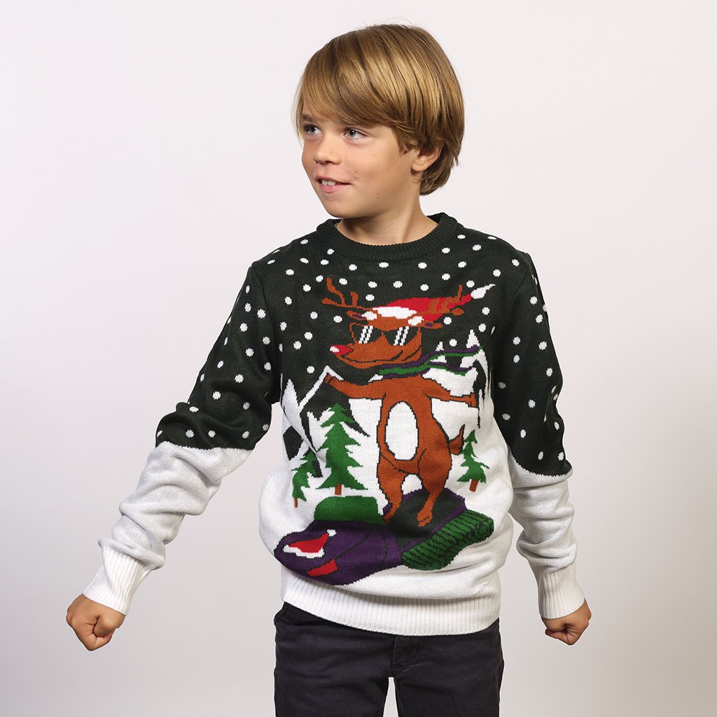 Un bambino in posa che indossa un maglione natalizio con un cervo in sella a uno scooter.
